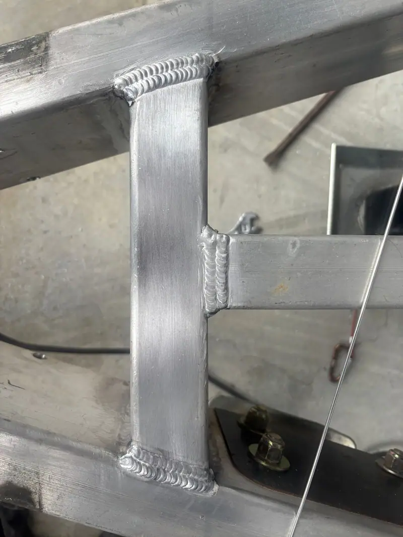 Fresh TIG welds joining an aluminum frame