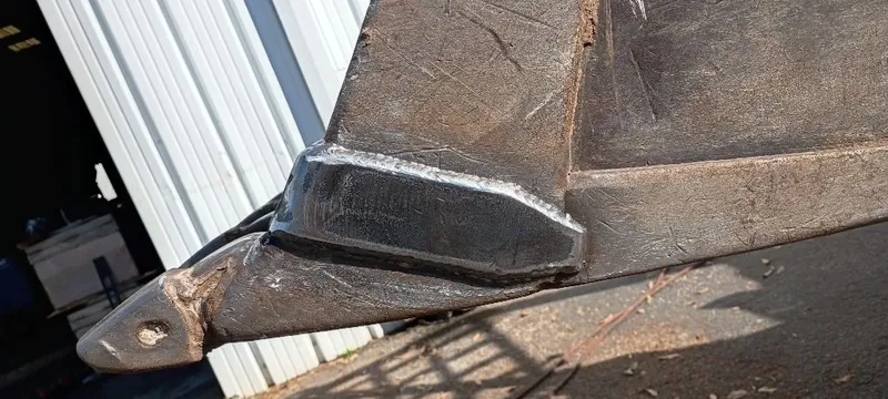 Welded reinforcement on a bucket corner next to the tooth adapter pin hole