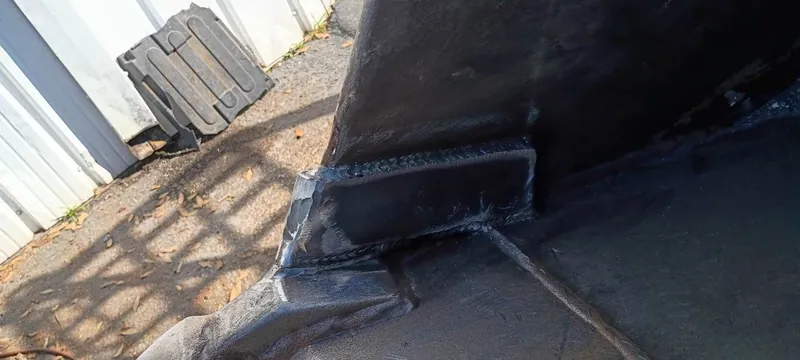 Steel wear block welded onto the corner of a heavy equipment bucket