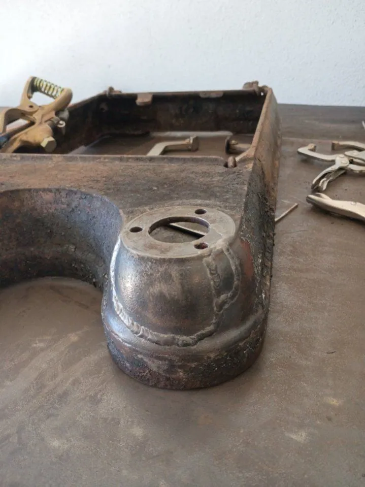 Weld bead run around the round mounting boss of an old cast-iron part on the shop table