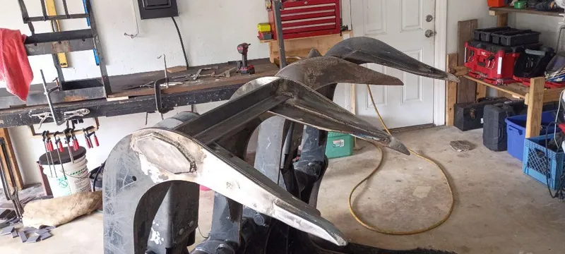 Curved steel tines with new welded plate, being rebuilt in the garage shop