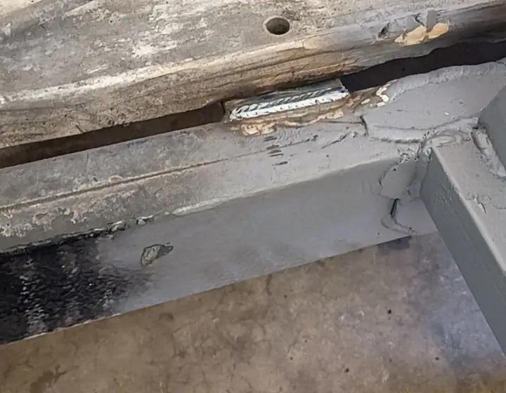 Fresh weld bead on a steel frame under wood deck boards
