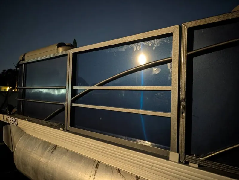 Aluminum pontoon rail panels with curved accent bars, photographed after dark