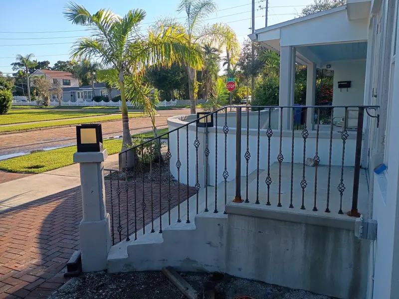 Porch railing with twisted balusters on a Florida home lined with palm trees