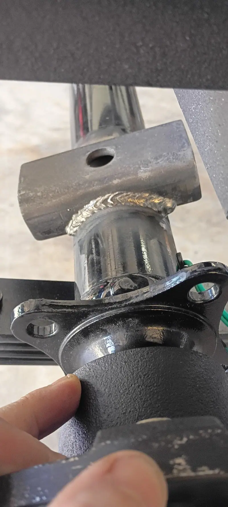 Fresh weld bead joining a steel spindle to its bracket