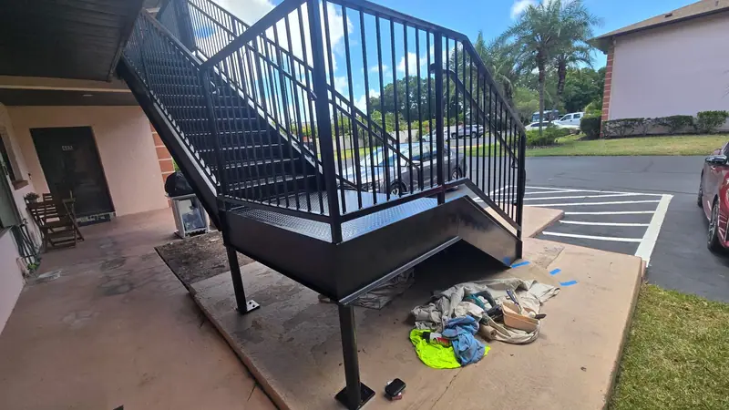 New black steel exterior staircase with railings at an apartment building